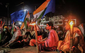 Women holding Indian national and United Nations flags take part in a demonstration, in Imphal on 18 July 2023, demanding the restoration of peace in India's north-eastern Manipur state following ongoing ethnic violence in the state.