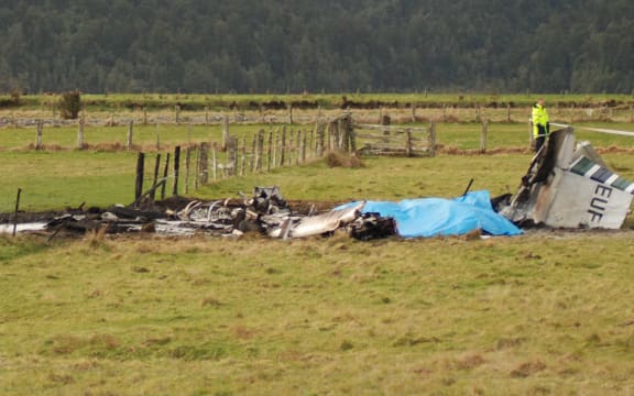 The wreckage of the crashed skydiving plane is seen at the end of the runway at Fox Glacier Airport on 4 September, 2010.