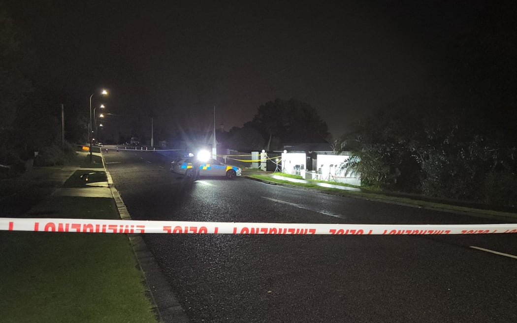 Police outside a house in in Henderson, West Auckland, where a woman was killed in a shooting.