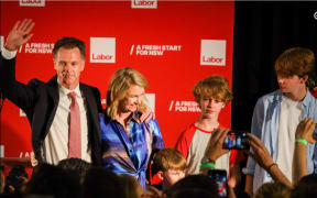 Chris Minns with his family waves to supporters after victory in the NSW election.