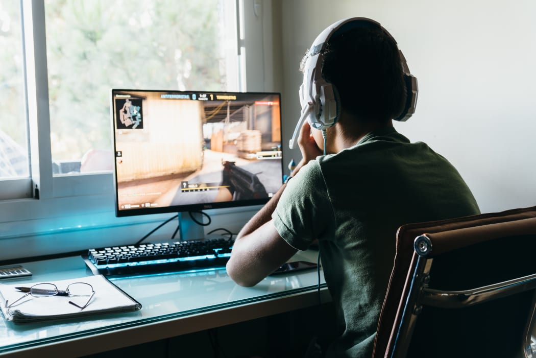 Teenager playing Counter Strike Global Offensive video game on PC. CSGO is an online multiplayer video game developed by Valve