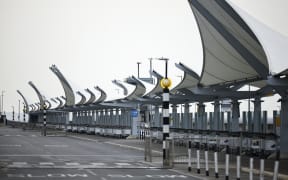 A photograph taken on March 21, 2025 shows trolleys lined up at the empty arrival area outside Terminal 5 of Heathrow airport following its closure after a fire broke out at a substation supplying power of the airport, in Hayes, west London. Britain's Heathrow airport, Europe's busiest, was shut down early on March 21 for 24 hours after a major fire at an electricity substation cut power to the sprawling facility west of London, officials said. (Photo by BENJAMIN CREMEL / AFP)