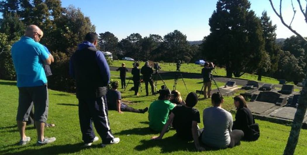Friends of Blessie Gotingco gather at the cemetery. A blue police tent is in the background.