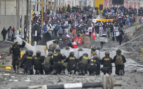 Demonstrators clash with riot police at the Añashuayco bridge in Arequipa, Peru, during a protest against the government of President Dina Boluarte and to demand her resignation on January 19, 2023. - After weeks of unrest, thousands of protesters were expected to descend on Peru's capital Lima, defying a state of emergency to express their anger with President Dina Boluarte, who called on the demonstrators to gather "peacefully and calmly". The South American country has been rocked by over five weeks of deadly protests since the ouster and arrest of her predecessor Pedro Castillo in early December. (Photo by Diego Ramos / AFP)