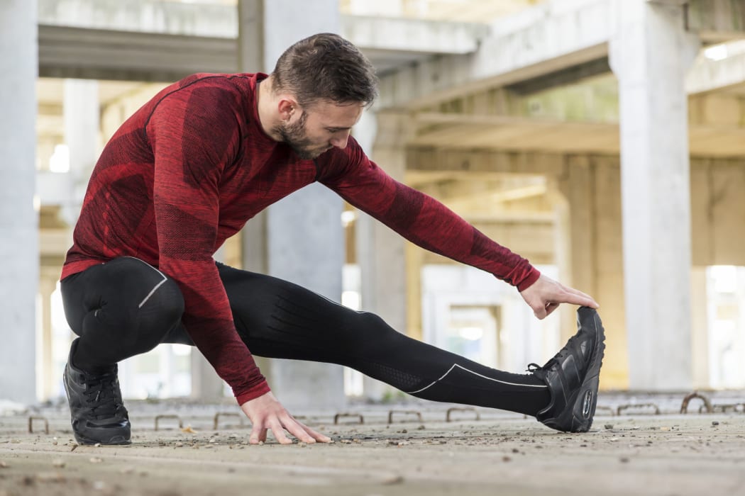 Athletic, muscular man stretching. out and warming up for a workout