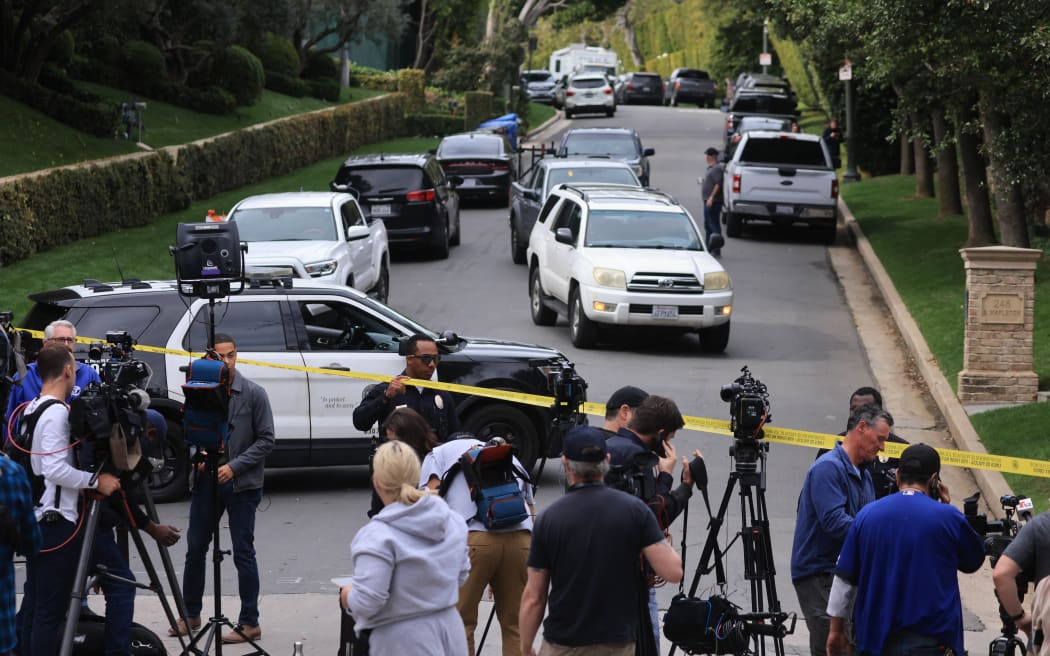 Police and members of the media gather outside the home of US producer and musician Sean 