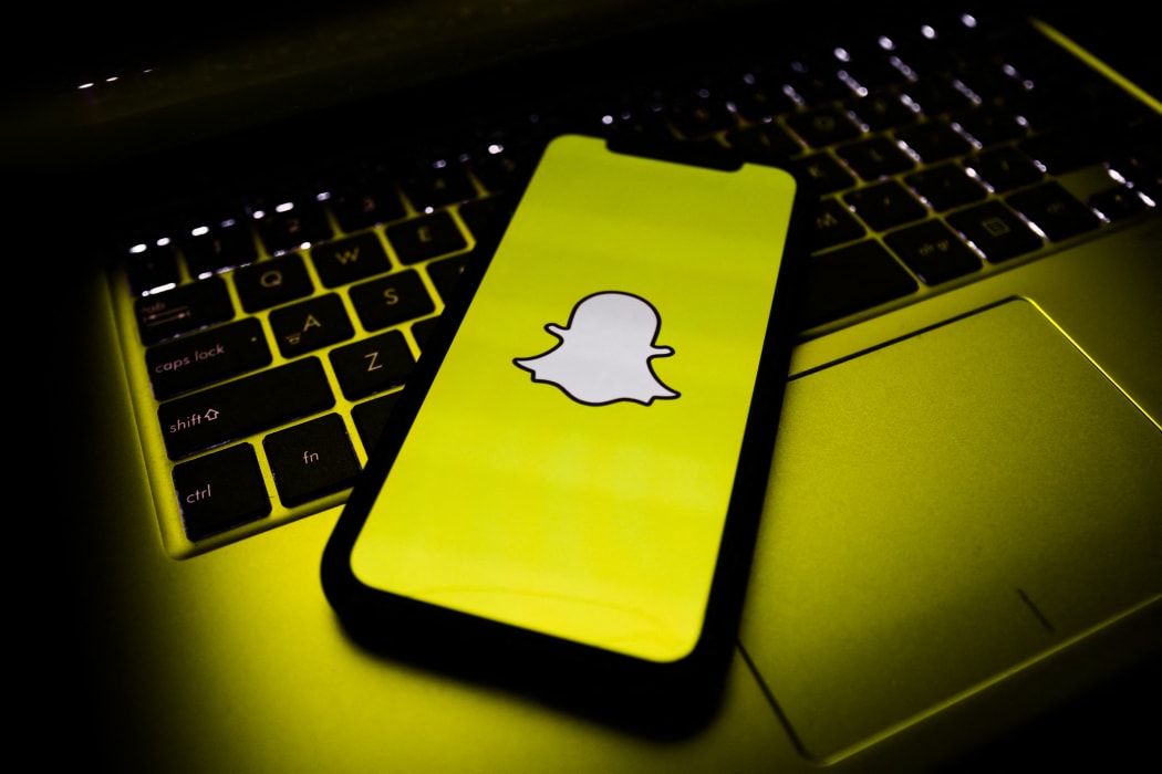 A phone, showing the Snapchat logo.