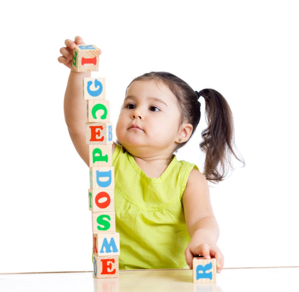 A photo of a girl playing with block toys on white background
