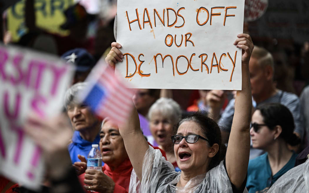 Demonstrators rally during the nationwide 'Hands Off!' protest against US President Donald Trump and his advisor, Tesla CEO Elon Musk, in Houston, Texas.