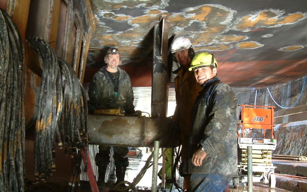 Niwa marine technician Steve Wilcox (left) under the Niwa vessel Tangaroa replacing seafloor-mapping transducers. 