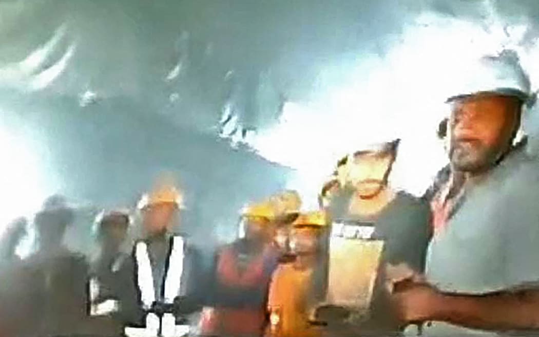 This picture released by Department of Information and Public Relation (DIPR) Uttarakhand and taken with endoscopic camera on November 21, 2023 shows a group of workers trapped inside the under-construction tunnel, days after it collapsed in the Uttarkashi district of India's Uttarakhand state. Forty-one Indian workers trapped in a collapsed road tunnel for 10 days were seen alive on camera for the first time November 21 as workers attempted to create new passageways to free them.