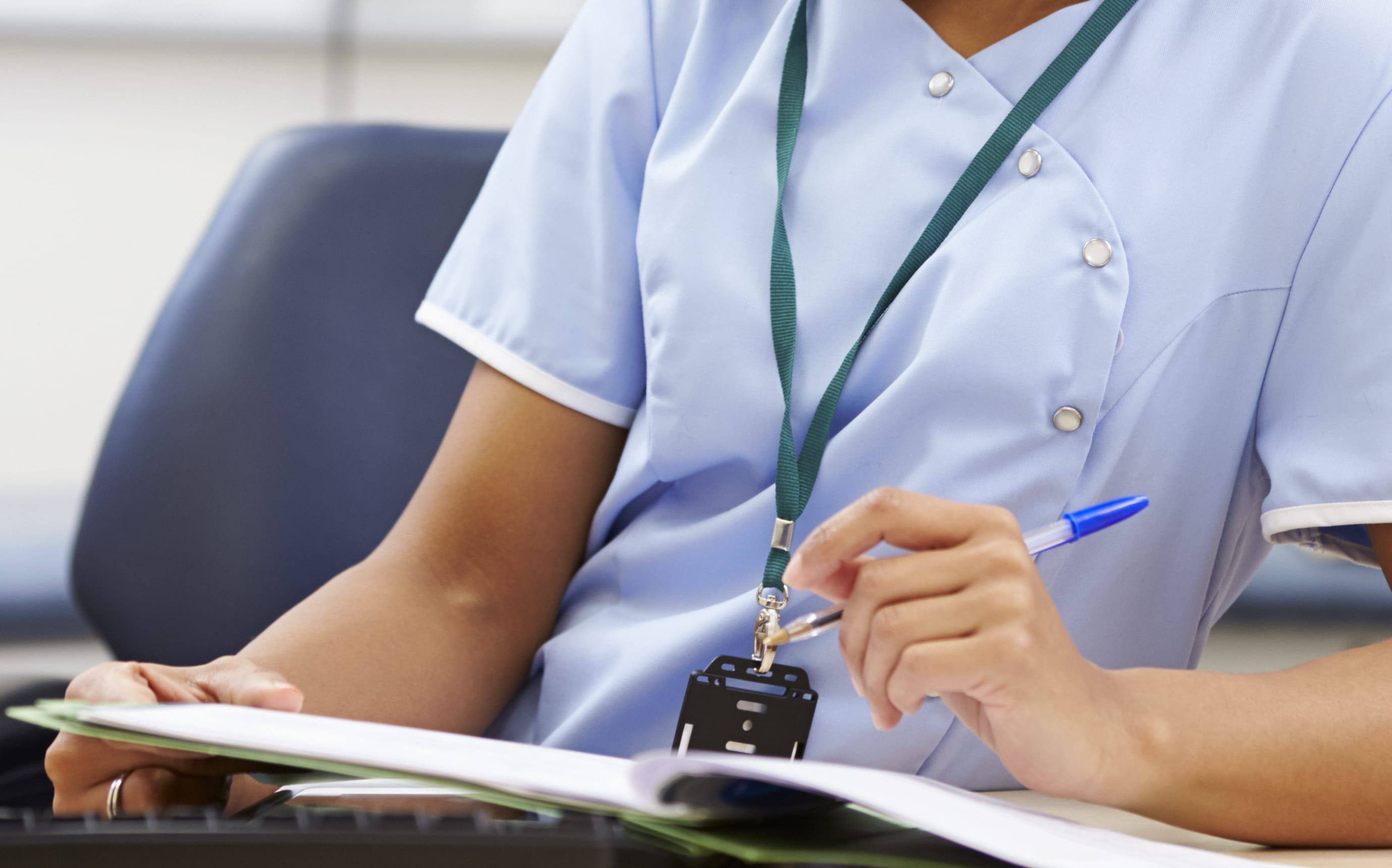 Portrait Of Female Nurse Working At Desk In Office