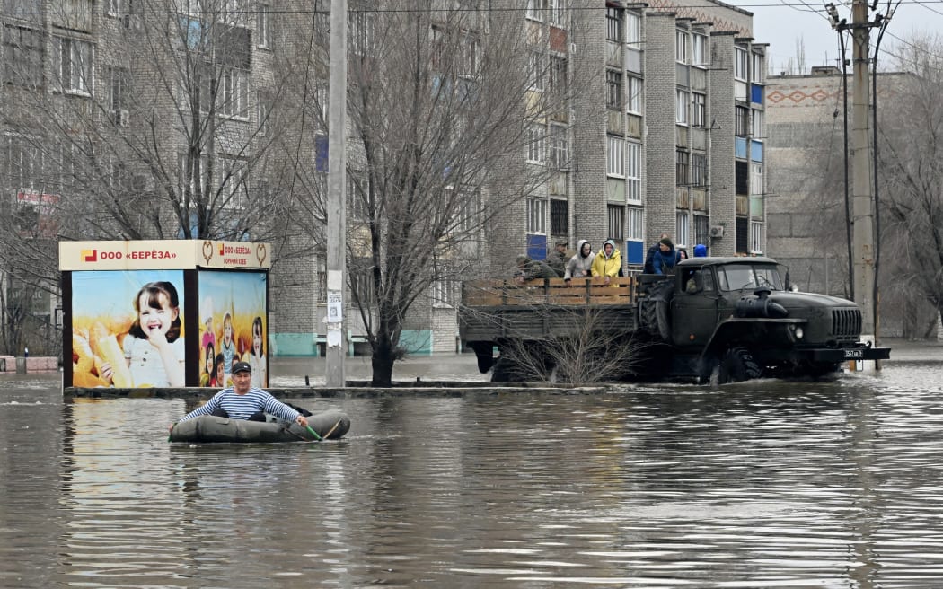 A picture taken on April 8, 2024 shows rescuers evacuating residents from the flooded part of the city of Orsk, Russia's Orenburg region, southeast of the southern tip of the Ural Mountains. Russia said on April 8, 2024 that more than 10,000 residential buildings were flooded across the Urals, Volga area and western Siberia as emergency services evacuated cities threatened by rising rivers. On April 7, Russia declared a federal emergency in the Orenburg region, where the Ural river flooded much of the city of Orsk and is now reaching dangerous levels in the main city of Orenburg. Much of the city of Orsk has been flooded after torrential rain burst a nearby dam. (Photo by Anatoliy Zhdanov / Kommersant Photo / AFP) / Russia OUT