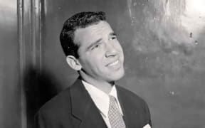Drummer Buddy Rich wearing a suit and looking up
