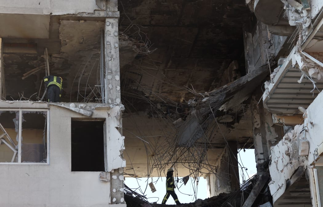 Rescuers clear debris in a damaged building in Odessa, southern Ukraine on April 24, 2022, which was reportedly hit by missile strike.