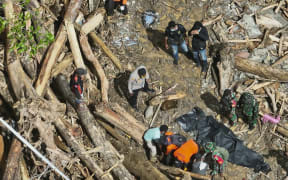 This handout photo taken and released on May 19, 2025 by Indonesia’s search and rescue agency (BASARNAS) shows rescuers recovering bodies after hours of heavy rain triggered flooding and a landslide near a gold mine in a remote area near Manokwari, West Papua. A flood and landslide near a gold mine in remote eastern Indonesia killed at least six people and rescuers were searching for more than a dozen missing, officials said on on May 19. (Photo by Handout / Indonesia Search and Rescue Agency (BASARNAS) / AFP) / RESTRICTED TO EDITORIAL USE - MANDATORY CREDIT "AFP PHOTO /  INDONESIA SEARCH AND RESCUE AGENCY (BASARNAS) " - NO MARKETING NO ADVERTISING CAMPAIGNS - DISTRIBUTED AS A SERVICE TO CLIENTS
