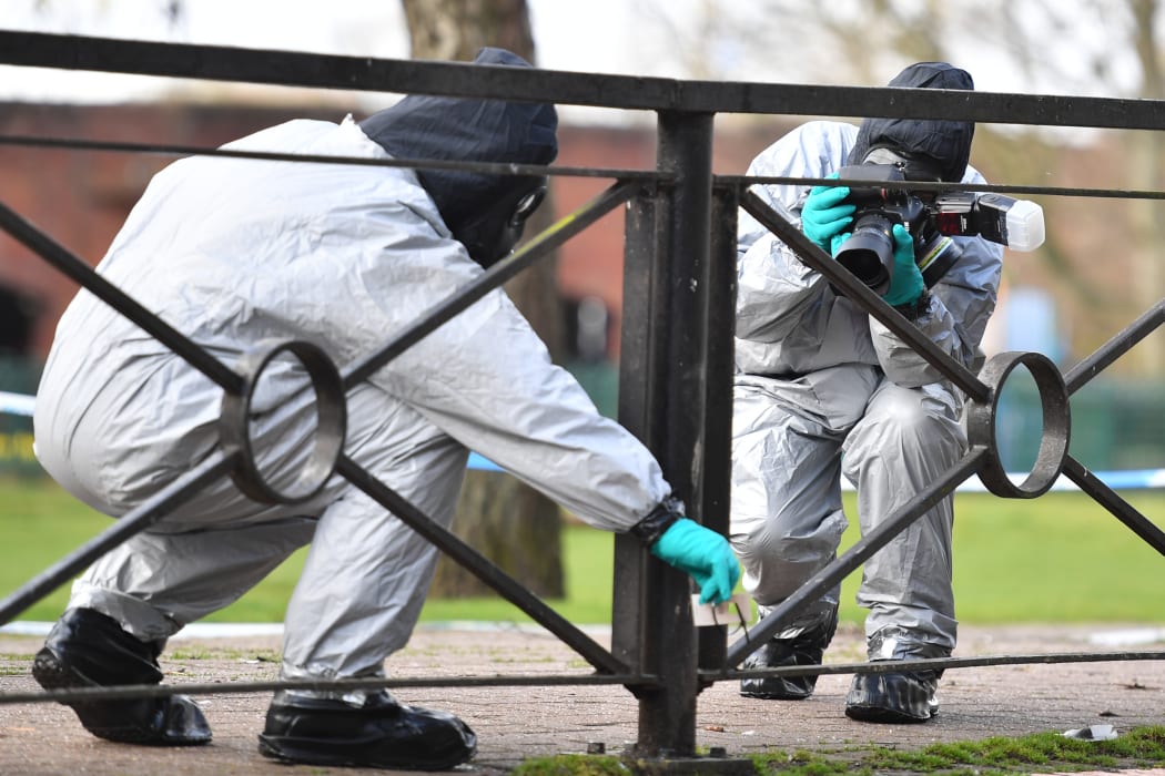 Personel take photographs as they swab railings near a bench covered in a protective tent at The Maltings shopping centre in Salisbury, southern England, on March 16, 2018.