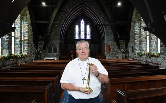 St Paul’s Anglican Church priest Chris Williams with the returned candlestick, dedicated to his grandfather Percy Williams.