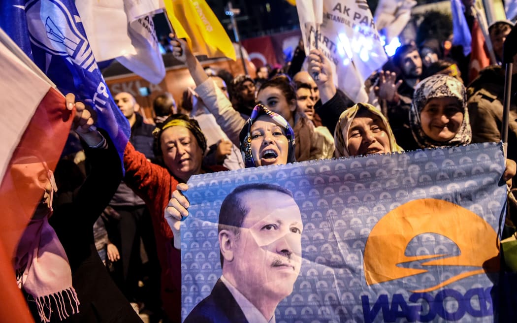 AKP supporters in Istanbul holding a flag with a portrait of President Recep Tayyip Erdogan as they celebrate the election result.