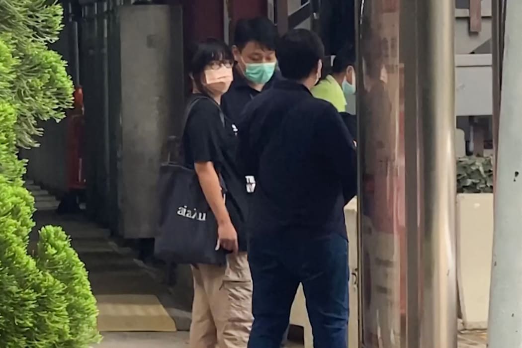 Chow Hang-tung (L), barrister and a leader of the Hong Kong Alliance in Support of Patriotic Democratic Movements of China, being led away by plainclothes police officers after being detained in Hong Kong on June 4, 2021, the anniversary of Beijing's deadly Tiananmen crackdown.