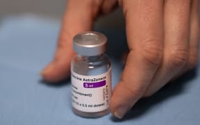 A pharmacist holds a vial of the AstraZeneca/Oxford Covid-19 vaccine in a pharmacy, in Savenay, western France, on April 2, 2021. (Photo by LOIC VENANCE / AFP)