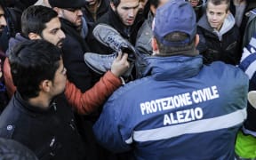 Migrants gather at a first aid centre after arriving in Italy aboard the Moldovan-flagged ship Blue Sky M.