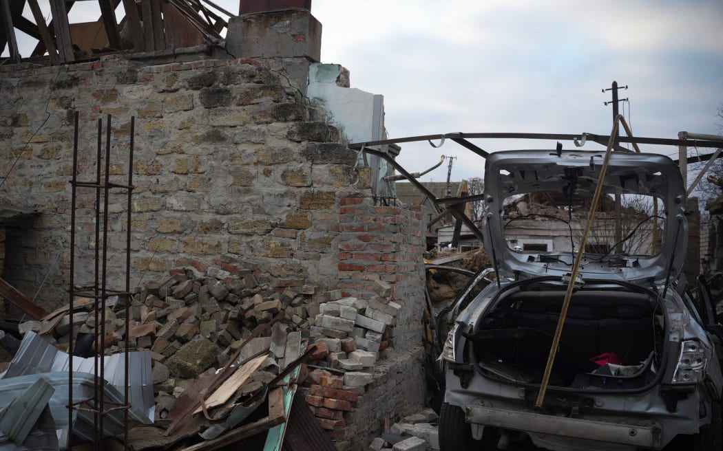 This handout photograph taken and released by the Ukrainian Emergency Service on November 17, 2024 shows a car and buildings destroyed as a result of a drone attack in Mykolaiv. - Ukraine's energy operator DTEK on November 17, 2024 announced "emergency power cuts" in the Kyiv region and two others in the east after authorities revealed Russia had launched a "massive" aerial attack on the energy grid. (Photo by Handout / UKRAINIAN EMERGENCY SERVICE / AFP) / RESTRICTED TO EDITORIAL USE - MANDATORY CREDIT "AFP PHOTO / UKRAINIAN EMERGENCY SERVICE" - NO MARKETING NO ADVERTISING CAMPAIGNS - DISTRIBUTED AS A SERVICE TO CLIENTS