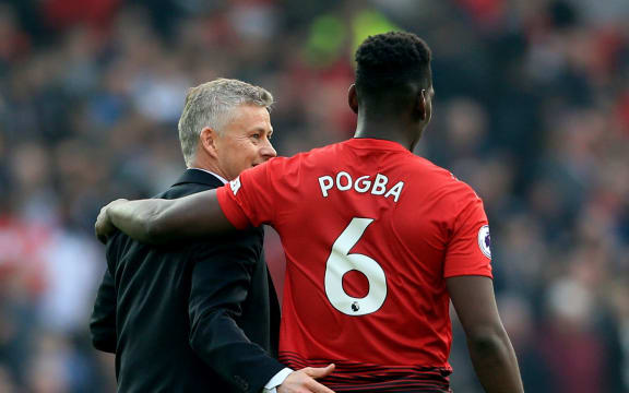 Manchester United manager Ole Gunnar Solskjaer hugs Paul Pogba.