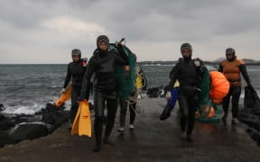 JEJU, SOUTH KOREA - NOVEMBER 06:  South Korean haenyeo exit the water after catching turban shells and abalones while diving on November 6, 2015 in Jeju, South Korea. "Haenyeo," or Sea Women are the female divers in Jeju Island. In 2014, South Korea applied to UNESCO to add the haenyo to its Intangible Cultural Heritage List, and it has been under examination by the committee.  (Photo by Chung Sung-Jun/Getty Images)