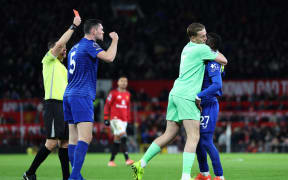 Everton's English goalkeeper #01 Jordan Pickford (2R) separates Everton's Senegalese midfielder #27 Idrissa Gueye (R) from Everton's English defender #05 Michael Keane (2L) as English referee Tony Harrington (L) shows a red card to Gueye during the English Premier League football match between Manchester United and Everton at Old Trafford in Manchester, north west England, on November 24, 2025. (Photo by Darren Staples / AFP) / RESTRICTED TO EDITORIAL USE. NO USE WITH UNAUTHORIZED AUDIO, VIDEO, DATA, FIXTURE LISTS, CLUB/LEAGUE LOGOS OR 'LIVE' SERVICES. ONLINE IN-MATCH USE LIMITED TO 120 IMAGES. AN ADDITIONAL 40 IMAGES MAY BE USED IN EXTRA TIME. NO VIDEO EMULATION. SOCIAL MEDIA IN-MATCH USE LIMITED TO 120 IMAGES. AN ADDITIONAL 40 IMAGES MAY BE USED IN EXTRA TIME. NO USE IN BETTING PUBLICATIONS, GAMES OR SINGLE CLUB/LEAGUE/PLAYER PUBLICATIONS. /