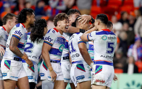 Warrior Leka Halasima celebrates with teammates after scoring against the Newcastle Knights.