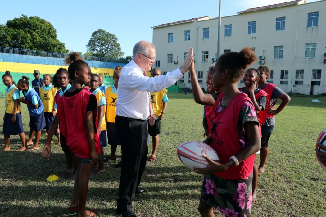 Australia's Prime Minister Scott Morrison plays rugby with school children in Honiara.