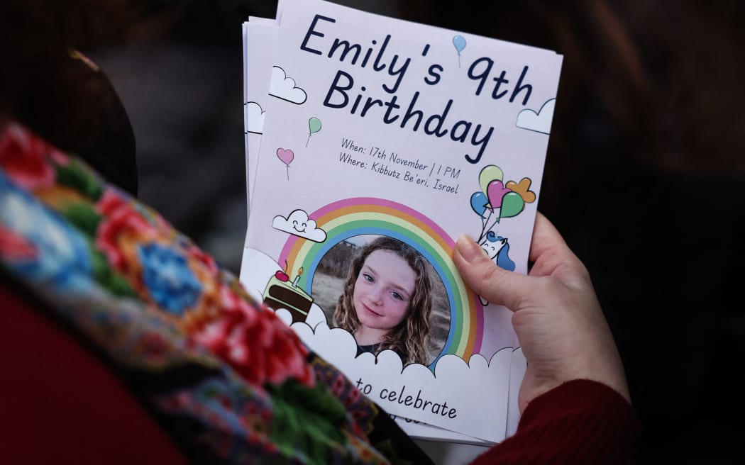 A woman holds leaflets picturing Irish-Israeli girl Emily Hand held hostage by Palestinian militant group Hamas in Gaza during a gathering for her 9th birthday outside the office of Save The Children International in London on November 17, 2023. About 1,200 people, mostly civilians, were killed in Israel and and around 240 people taken hostage, according to Israeli officials following the Hamas attack of October 7, 2023. Israel has vowed to eradicate Hamas in retaliation for October 7 assault. Its relentless bombardment and growing ground offensives has left more than 11,500 people dead, mostly civilians and including thousands of children, according to Gaza's Hamas-run health ministry. (Photo by Daniel LEAL / AFP)