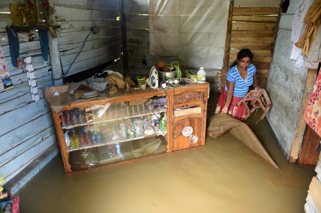 A Sri Lankan woman wades through floodwaters inside her home in Kelaniya suburb of the capital Colombo.