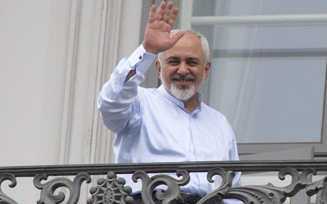 Iranian Foreign Minister Mohammad Javad Zarif waves from a balcony of the Palais Coburg Hotel where the Iran nuclear talks meetings were being held in Vienna.