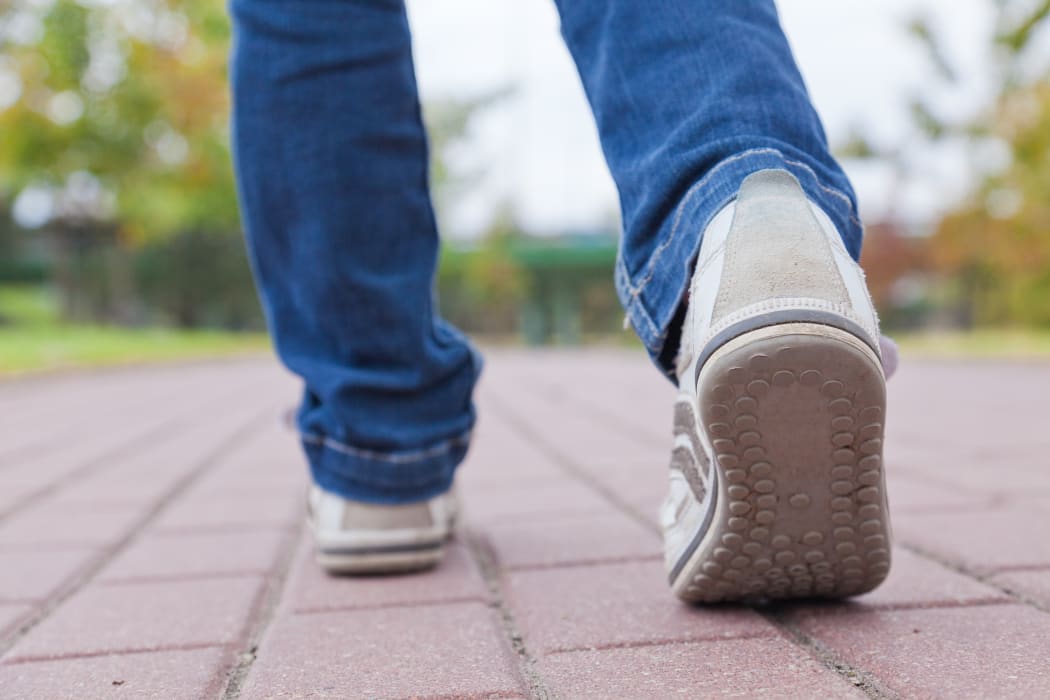 13409511 - teenager walking in sport shoes on pavement in autumn day