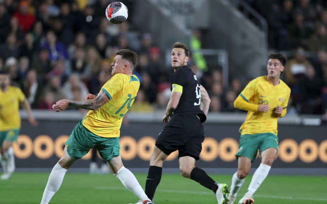 Chris Wood of New Zealand flicks a header towards goal against Australia.