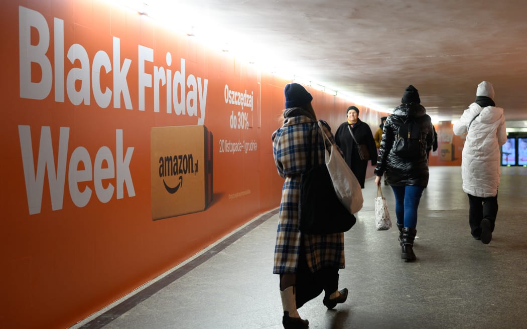 People walk past a Black Friday Week Amazon advertisement in Warsaw, Poland, on November 21, 2025. (Photo by Aleksander Kalka/NurPhoto) (Photo by Aleksander Kalka / NurPhoto via AFP)