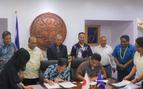 Japan Ambassador Norio Saito and Marshall Islands Foreign Minister Casten Nemra sign two agreements as President David Kabua and his Cabinet look on