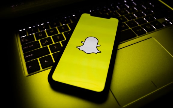 A phone, showing the Snapchat logo.