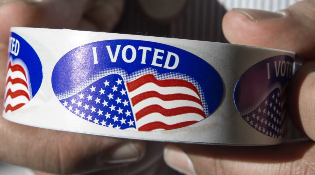An election official holds a roll of "I voted" stickers at Centreville High School in Centreville, Virginia on 1 March 2016, during the Super Tuesday primary voting.