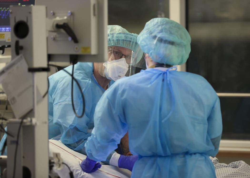 A specialist and an intensive care nurse intubate a Covid-19 patient in the intensive care unit of Leipzig University Hospital, Germany.