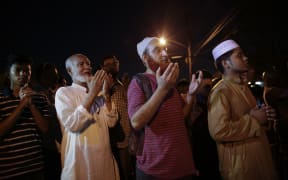 Community members pray outside the Al-Furqan Jame Mosque in Ozone Park after the fatal shootings.