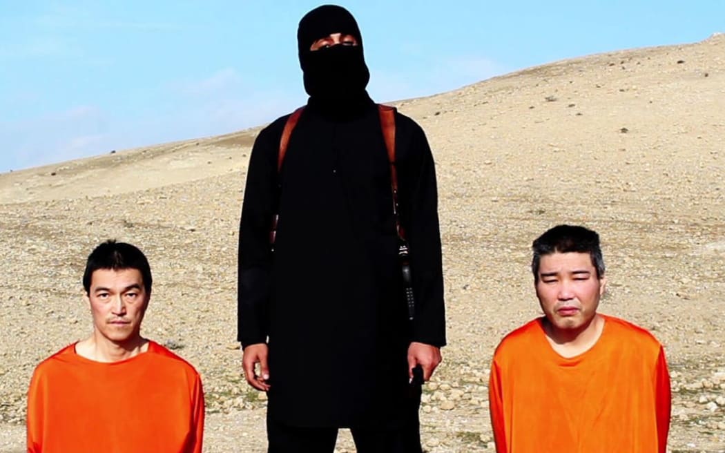 An image grab taken off a video on January 20, 2015, reportedly released by the Islamic State (IS) allegedly shows Japanese hostages Kenji Goto (L) and Haruna Yukawa (R).