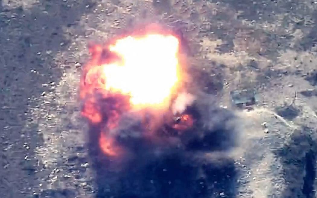 This grab taken from handout footage released by the Azerbaijani Defence Ministry on September 19, 2023 shows an explosion in mountainous terrain, that Baku claims to be Azerbaijani forces "destroying positions" used by Armenians in the Nagorno-Karabakh region. Azerbaijan said on September 19, 2023 it had launched "anti-terrorist operations" in the disputed region, over which the Caucasus arch-rivals fought a brief but brutal war in 2020. (Photo by Handout / Azerbaijani Defence Ministry / AFP) / RESTRICTED TO EDITORIAL USE - MANDATORY CREDIT "AFP PHOTO / Azerbaijani Defence Ministry / handout" - NO MARKETING NO ADVERTISING CAMPAIGNS - DISTRIBUTED AS A SERVICE TO CLIENTS