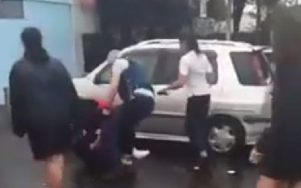 A screenshot from the video, showing policemen trying to intervene.