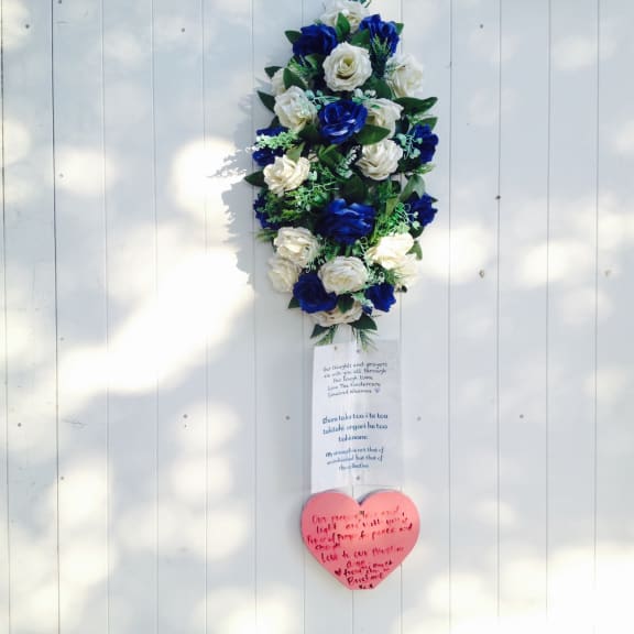 Flower bouquet and message left at Linwood Mosque before the one-year anniversary.