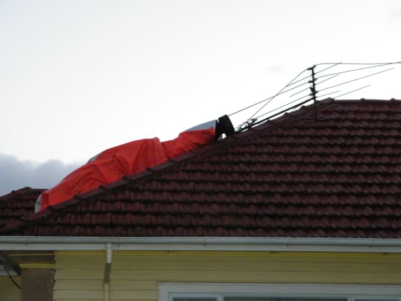 The chimney was torn off and broke a hole in the roof.