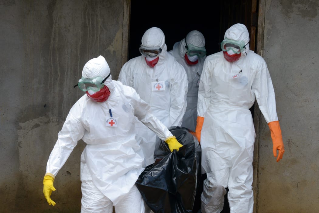 Medical workers of the Liberian Red Cross carry the body of a victim of the Ebola virus in a bag on 4 September.