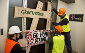 Protesters board up the Statoil office.
